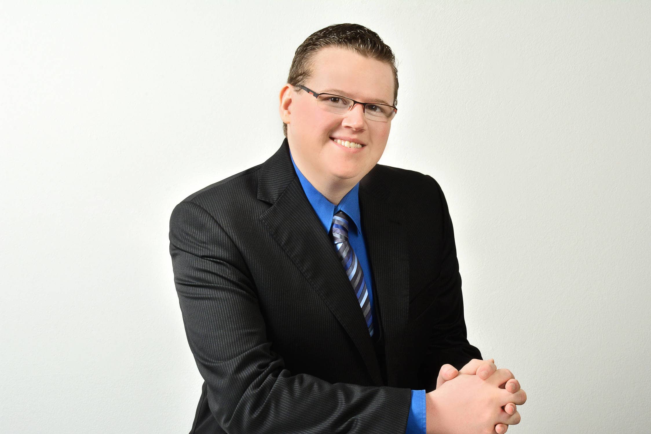 Foto von Daniel Rudolf in schwarzem Anzug mit blauem Hemd